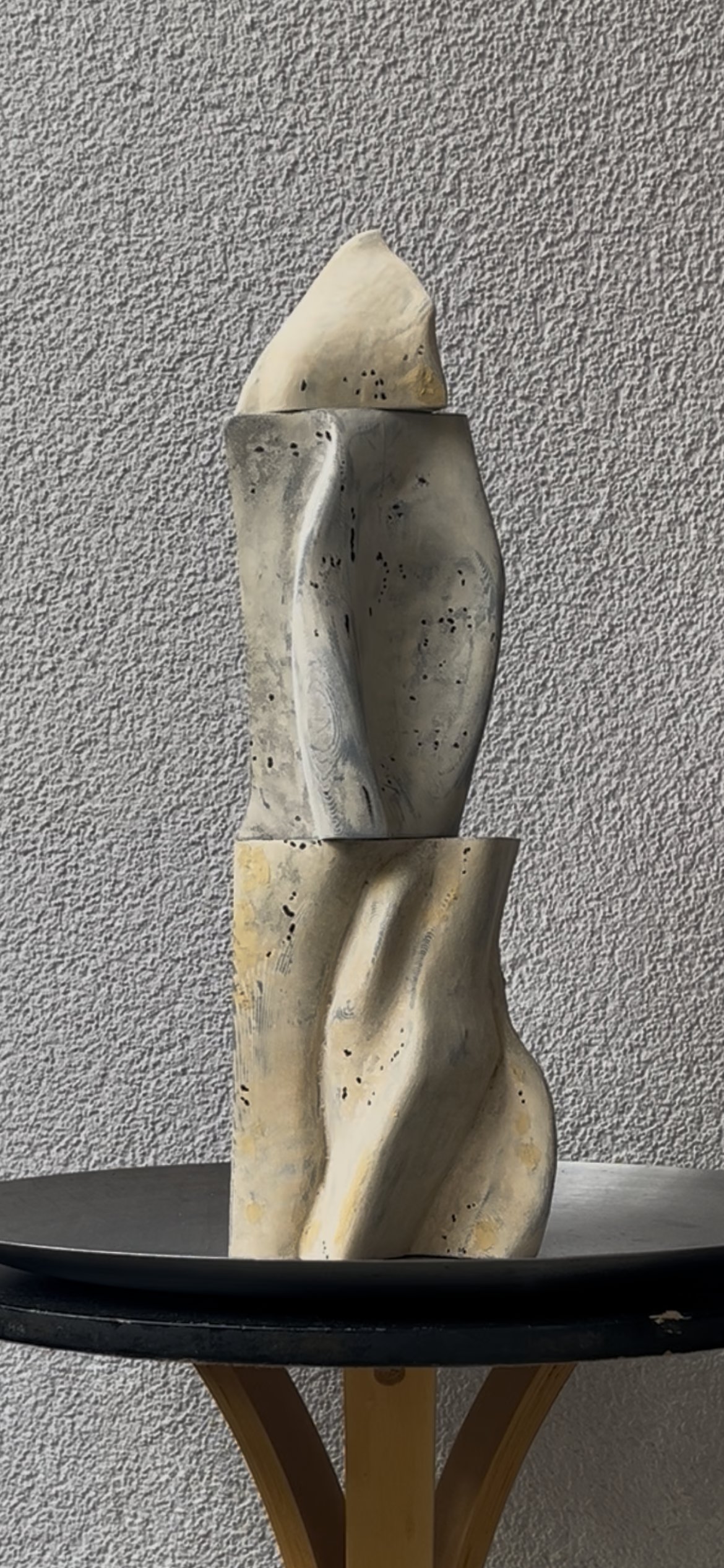 Study II: a tall, totem-like sculptural form in three stacked sections — a pointed cap, a twisted fluted midsection, and a draped, folded base — in grey and bone tones.